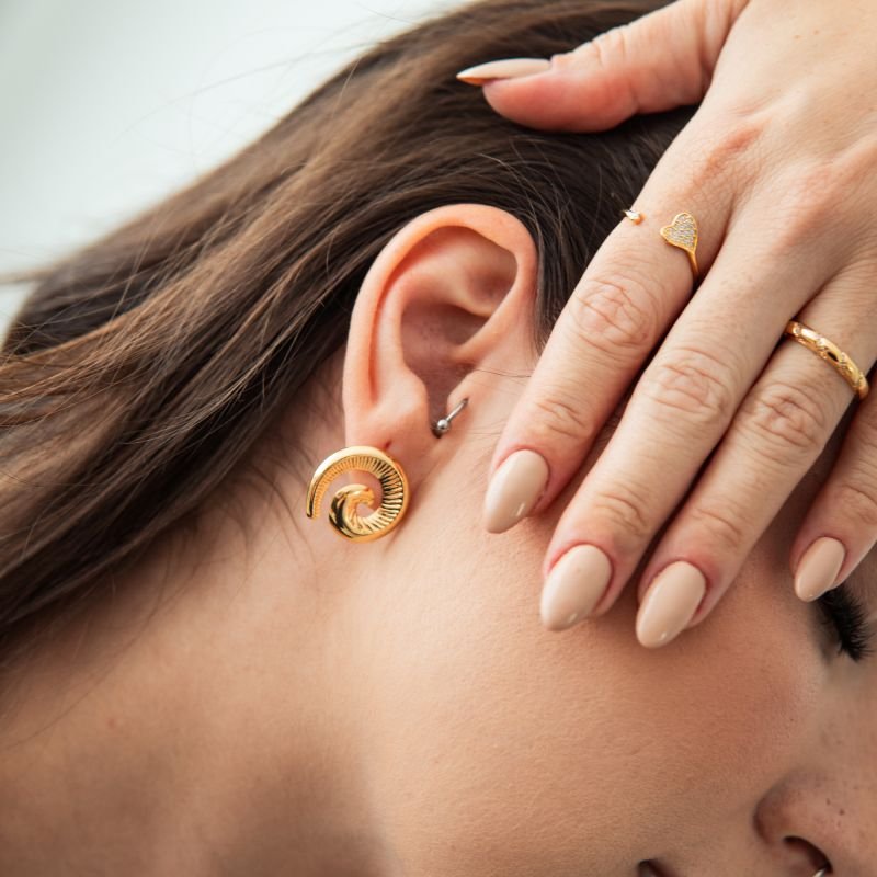 Anel aparador torcido com zircônias folheado a ouro 18k