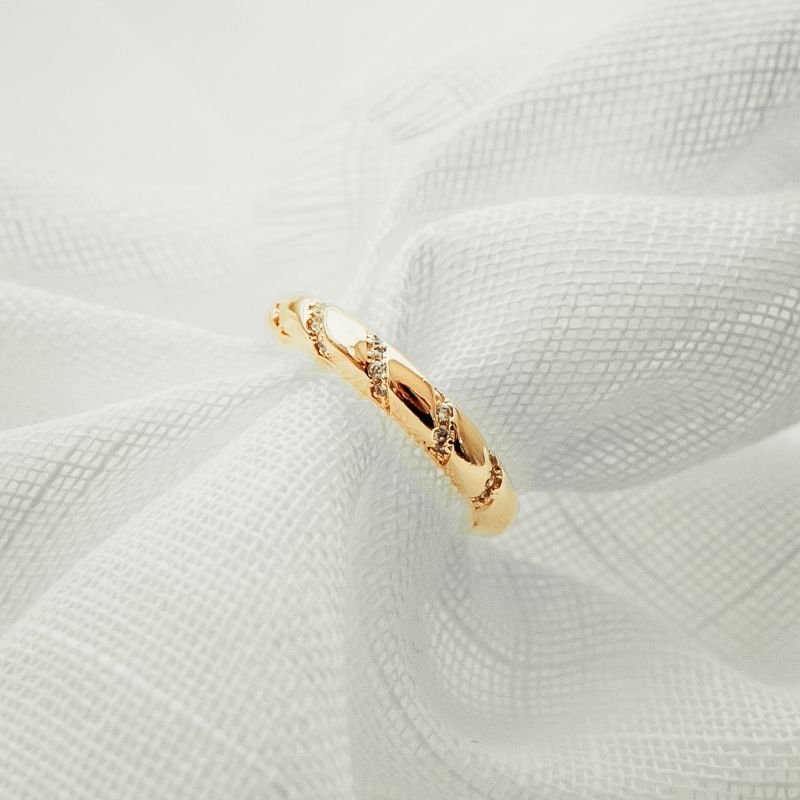 Anel aparador torcido com zircônias folheado a ouro 18k