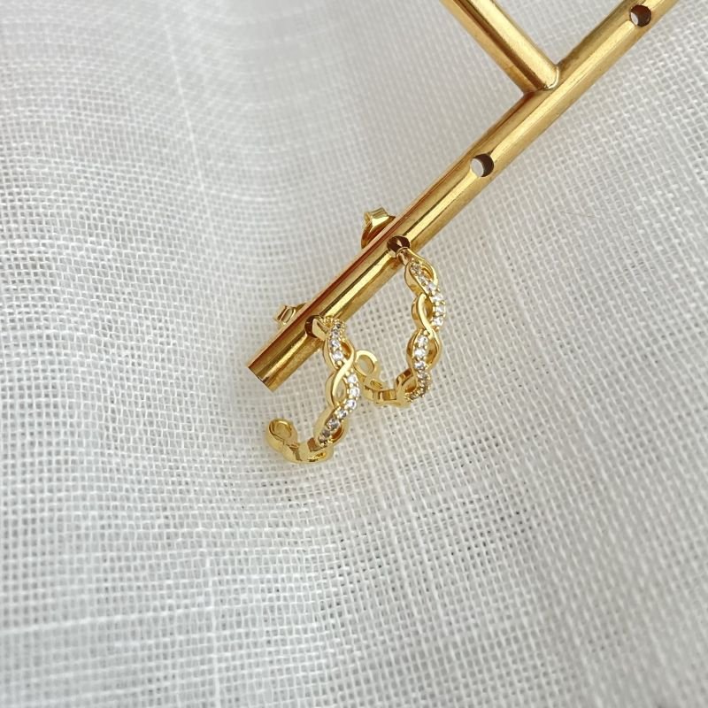 Argola trançada lisa e cravejada em zircônia folheada a ouro 18k