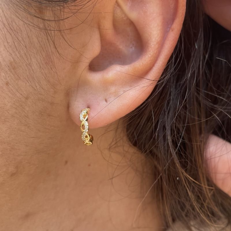 Argola trançada lisa e cravejada em zircônia folheada a ouro 18k