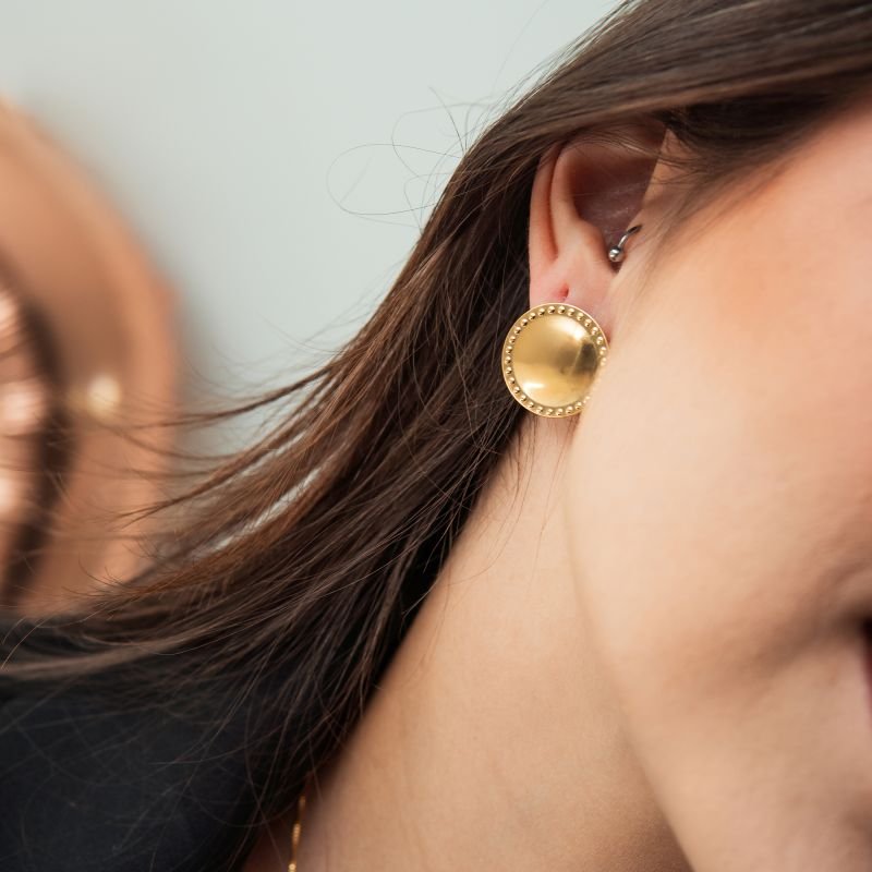 Brinco botão com detalhes em contorno folheado a ouro 18k