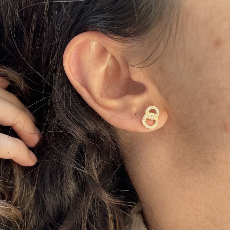 Brinco de círculos vazados e cravejados em zircônia folheado a ouro 18k