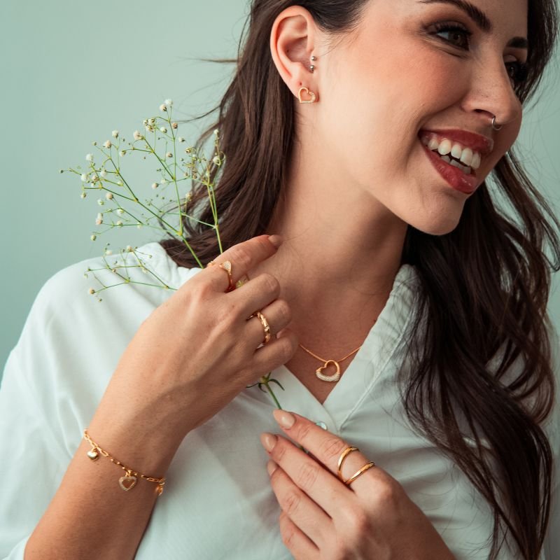Brinco de coração metade cravejado folheado a ouro 18k