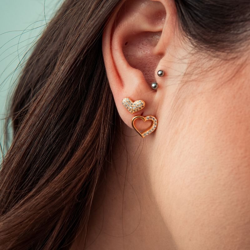 Brinco de coração metade cravejado folheado a ouro 18k