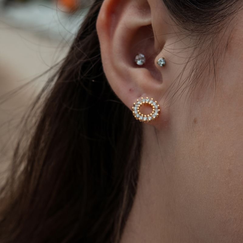 Brinco redondo com zircônias e detalhe vazado folheado a ouro 18k