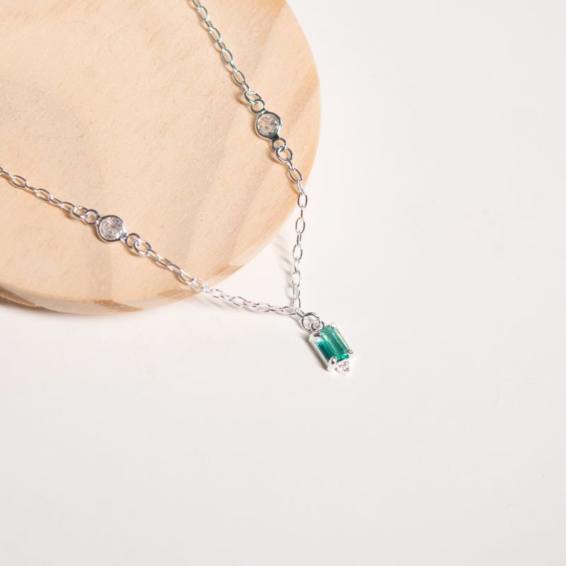 Colar com pontos de luz e pingente de zircônia verde e detalhe em zircônia branca folheado a prata