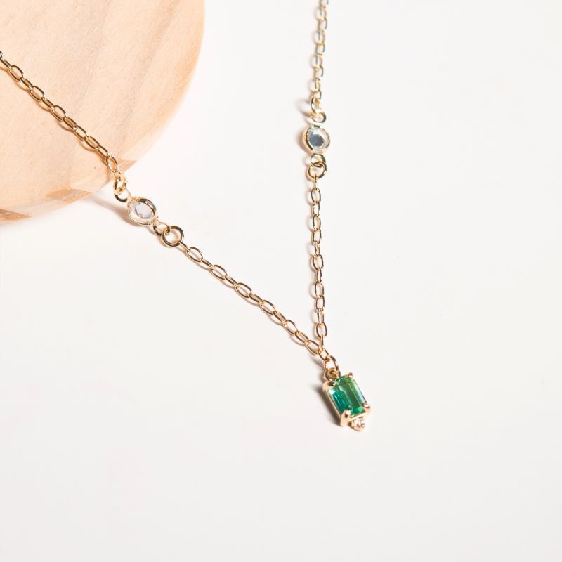 Colar com pontos de luz e pingente de zircônia verde e detalhe em zircônia branca folheado a prata