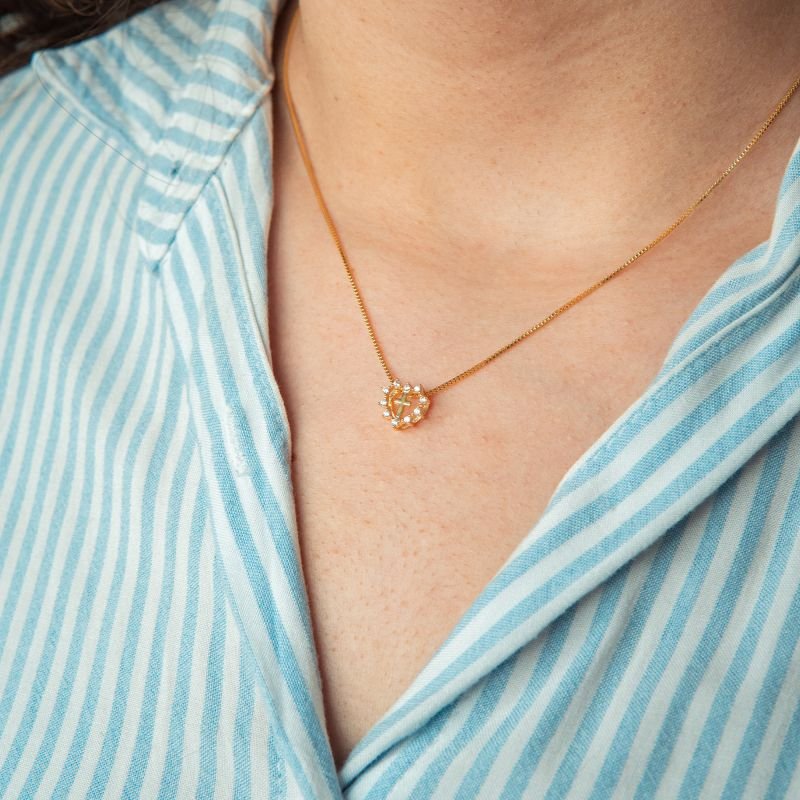 Colar de cruz com contorno e coração com pontos de luz folheado a ouro 18k