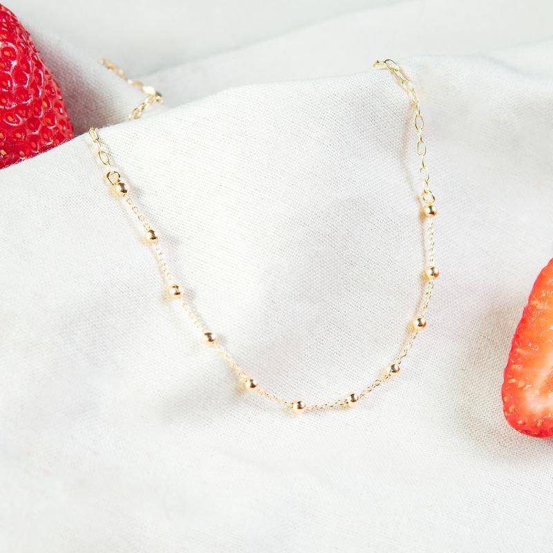 Tornozeleira de esferas lisas folheada a ouro 18k